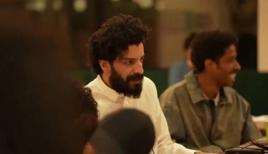 Alt: رجل وشخص يقيمون حديثاً في جو دافئ وودي أثناء تجمع اجتماعي.