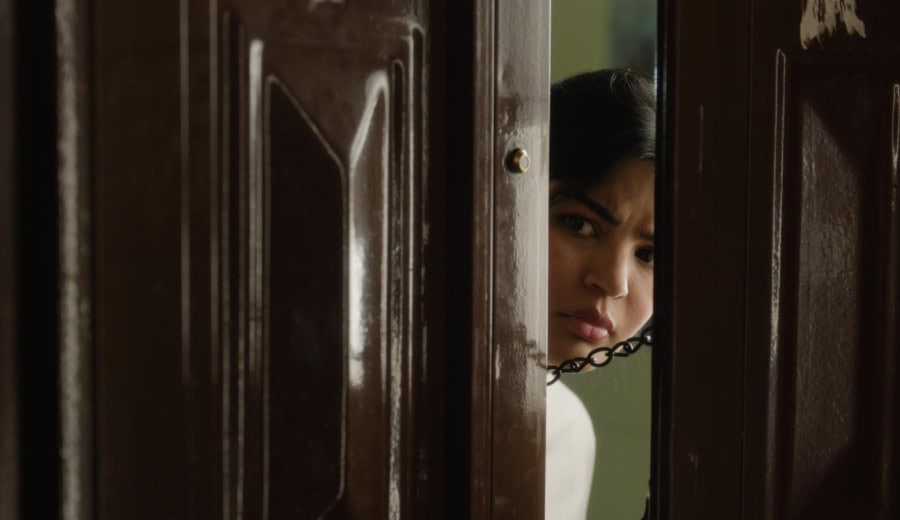 امرأة حزينة تتحدث عبر الهاتف على خلفية الأثاث الخشبي.